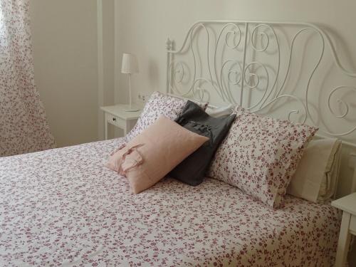 een bed met een wit hoofdeinde en kussens erop bij APARTAMENTO PISCINA VIENA in Roses