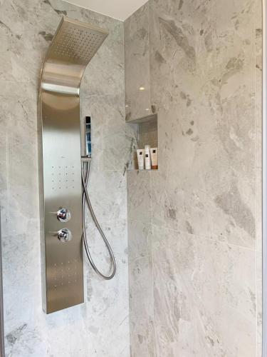 a shower stall in a bathroom with marble walls at El Encanto Villas Boutique in Ribadesella