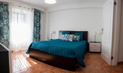 sypialnia z łóżkiem z niebieską narzutą w obiekcie Casa da Rocha - Alojamento Local w mieście Vila Nova de Foz Côa