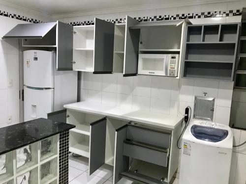 cocina con armarios blancos y lavadora en APARTAMENTO COPACABANA, 4 QUARTOS, 3 banheiros, en Río de Janeiro