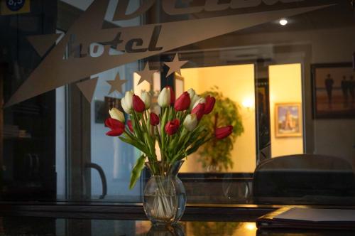 a vase of red and white tulips sitting on a table at Delta Hotel in Vylkove