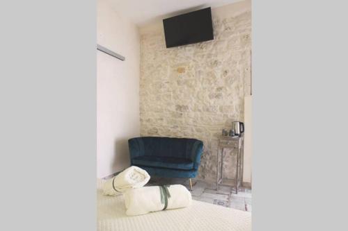 a room with a blue chair and a television at Le Marangi Getaway Suite in Martina Franca
