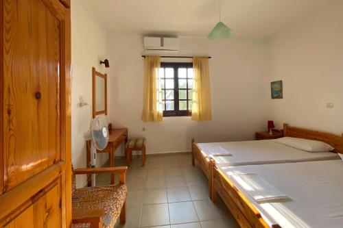 een slaapkamer met een bed, een bureau en een raam bij Bayview Apartments in Agios Nikolaos