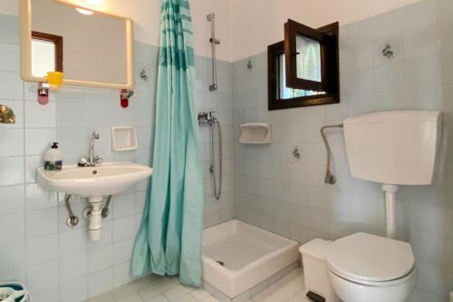y baño con aseo, lavabo y ducha. en Bayview Apartments, en Agios Nikolaos