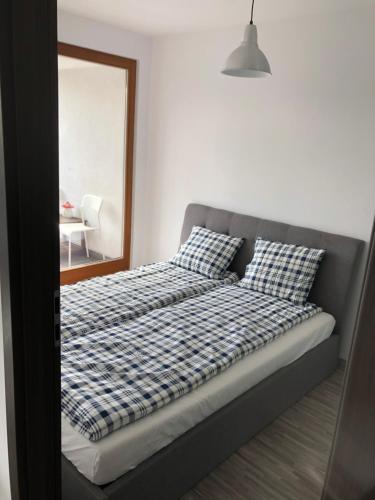 1 cama con sábanas a cuadros y espejo en un dormitorio en Apartament Ptasia, en Zielona Góra