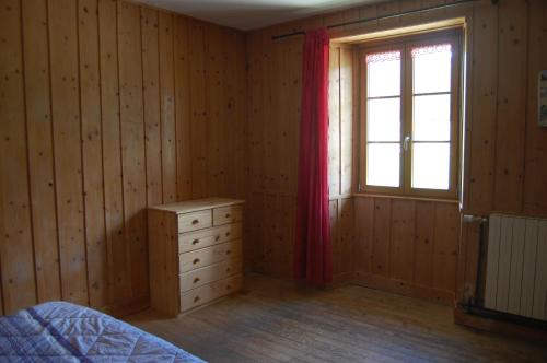 a bedroom with a bed and a window and a dresser at Maison de la Combe des Cives in Chapelle-des-Bois