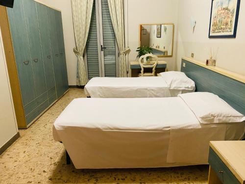 a hospital room with two beds and a mirror at Hotel Ferrucci in Turin