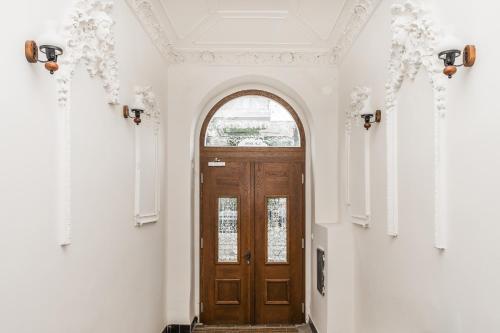 a hallway with a wooden door and an arched window at Apartmán u Stromovky nedaleko centra in Prague