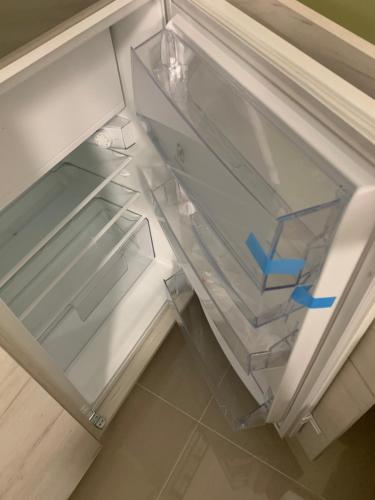 an empty refrigerator with the door open with a blue arrow at Sea&Center Lux in Bar