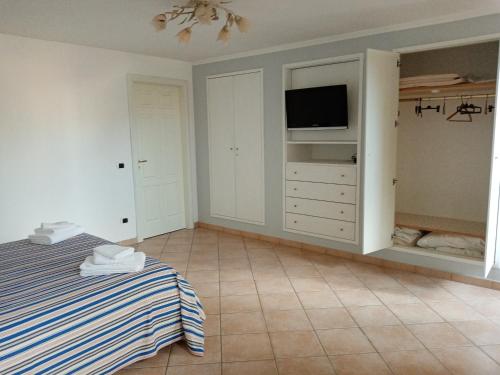a bedroom with a bed and a flat screen tv at The View House in Vico Equense