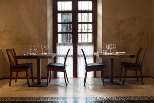 a dining room with two tables and chairs and a window at Ya'ax Hotel Boutique in Mérida