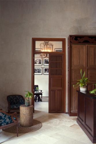 a room with a door and a chair and a table at Ya'ax Hotel Boutique in Mérida