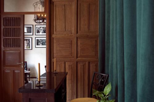 a room with a wooden door and a desk with a candle at Ya'ax Hotel Boutique in Mérida