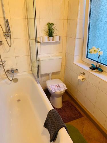 uma casa de banho com uma banheira branca e um WC. em Apartment Apfel em Mönchengladbach