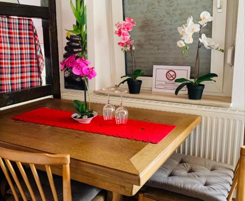 una mesa de comedor con una servilleta roja y flores en Apartment Apfel, en Mönchengladbach