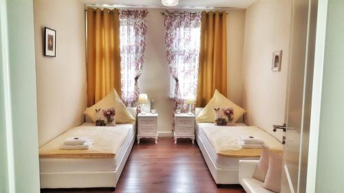 2 Betten in einem Zimmer mit 2 Fenstern in der Unterkunft Appartement am Bachhaus in Eisenach