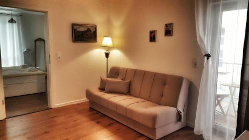a living room with a couch and a lamp at Appartements am Bachhaus in Eisenach