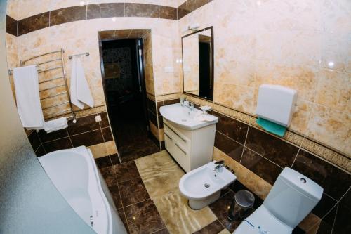 a bathroom with two sinks and a toilet and a mirror at Delta Hotel in Vylkove