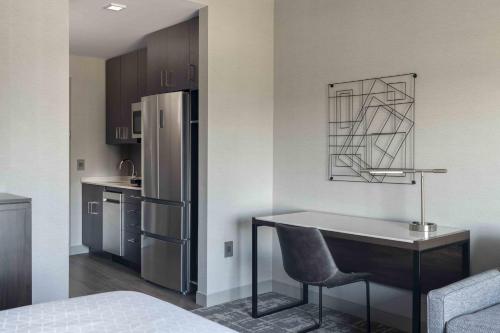 a kitchen with a desk and a refrigerator at Staybridge Suites - Boston Logan Airport - Revere by IHG in Revere