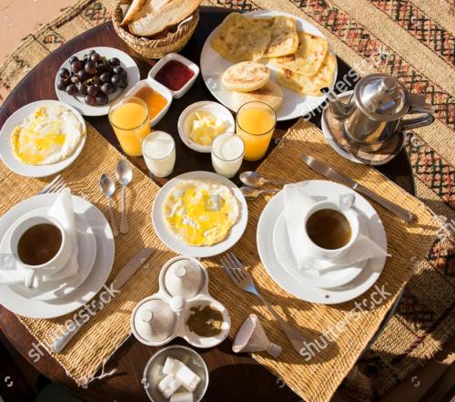 a table with breakfast foods and coffee on it at Hotel VIP Palace Lodge in Multan