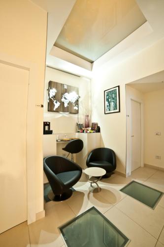 a living room with two black chairs and a table at Town House Cavour in Reggio Calabria