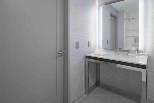 a white bathroom with a sink and a mirror at Staybridge Suites - Boston Logan Airport - Revere by IHG in Revere