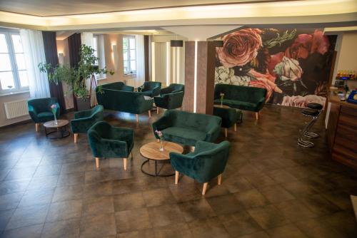 a waiting room with green chairs and tables and a painting at Centrum Restauracyjno-Hotelowe Florres in Pawłowiczki