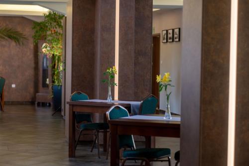 a restaurant with two tables and chairs with flowers on them at Centrum Restauracyjno-Hotelowe Florres in Pawłowiczki