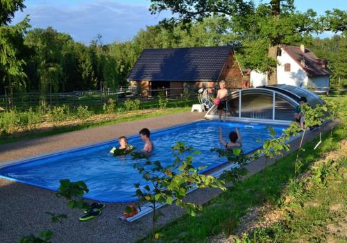 a group of people sitting in a swimming pool at Smrcina Resort in Smrčina