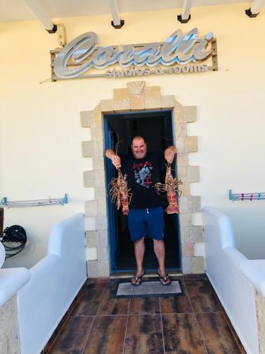 a man standing in the doorway of a restaurant at Coralli Rooms & Restaurant in Elafonisos