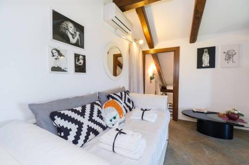 een woonkamer met een witte bank met kussens bij Domus Aqua Viva in Massa Lubrense
