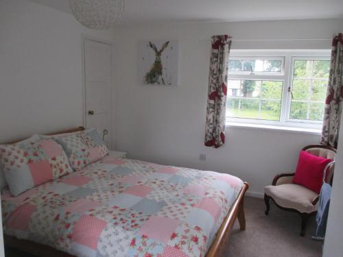 um quarto com uma cama, uma cadeira e uma janela em Hops Main House, Brockenhurst, New Forest em Brockenhurst