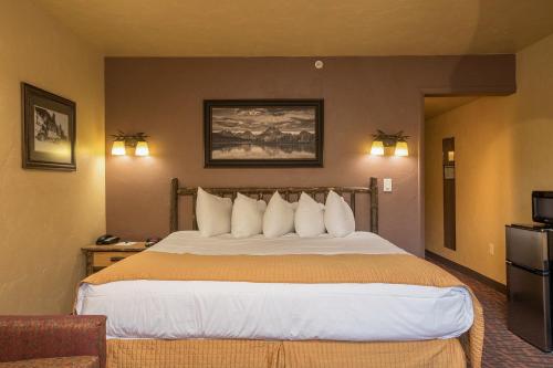 a hotel room with a large bed with white pillows at Elk Country Inn in Jackson