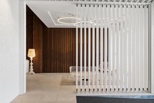 a white crib in a room with a chandelier at Ramada by Wyndham, Hamilton City Center in Hamilton