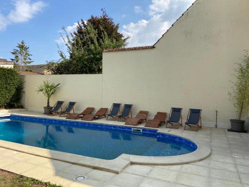 a group of chairs and a swimming pool at Au fil de l’Ô in Bisseuil