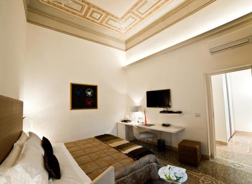 a bedroom with a bed and a desk and a ceiling at Town House Cavour in Reggio Calabria
