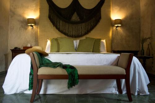a bedroom with a bed with green pillows at Ya'ax Hotel Boutique in Mérida