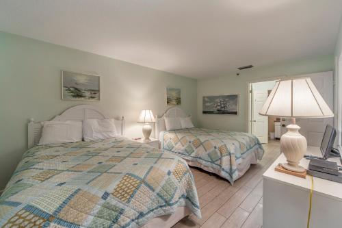 a bedroom with two beds and a television in it at 207 Beach Place Condos in St Pete Beach