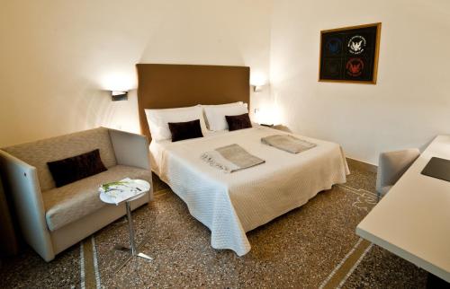 a bedroom with a large bed and a couch at Town House Cavour in Reggio Calabria