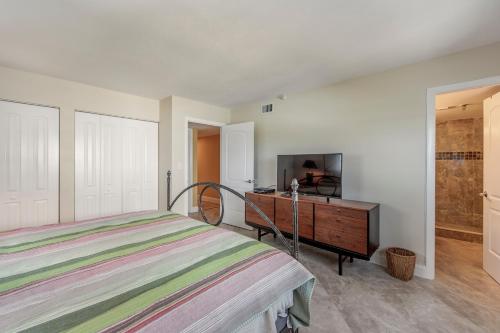 a bedroom with a bed and a dresser and a television at #505 Shores of Madeira in St. Pete Beach