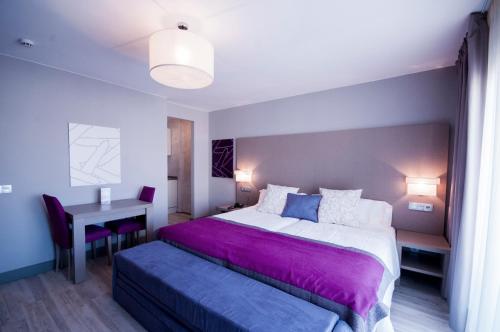 a bedroom with a large bed and a desk at Hotel El Faro Marbella in Marbella