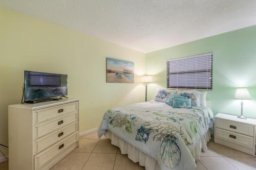 a bedroom with a bed and a flat screen tv at 407 Beach Place Condos in St Pete Beach