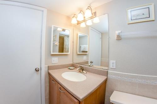 een badkamer met een wastafel, een spiegel en een toilet bij 414 Madeira Norte Condo in St Pete Beach