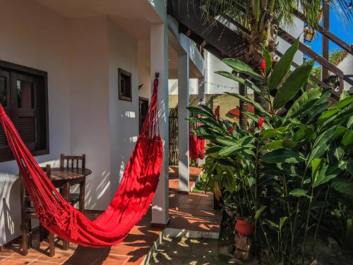 a red hammock in a room with a plant at Pousada Atlantis in Jericoacoara