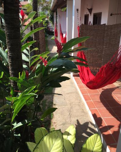 a red hammock hanging from a house with a plant at Pousada Atlantis in Jericoacoara
