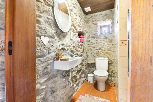 een stenen badkamer met een toilet en een wastafel bij AgroFarm with Animals - Qta Entre Sebes in Cabeceiras de Basto