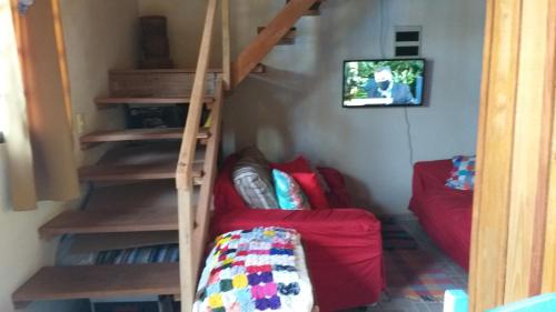 a living room with a staircase and a red couch at Chale para temporada - Bonito MS in Bonito