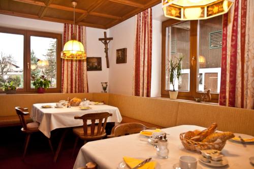 ウダーンスにあるEhstandhofのテーブル2台と窓2つ付きのレストラン