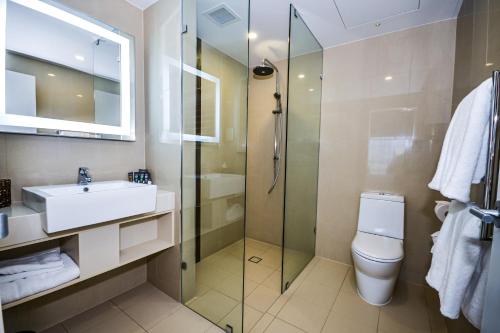 
a bathroom with a toilet, sink, and shower at Novotel Barossa Valley Resort in Rowland Flat
