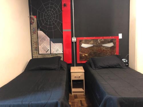 a bedroom with two beds and a painting on the wall at Hotel Brasilia Curitiba in Curitiba